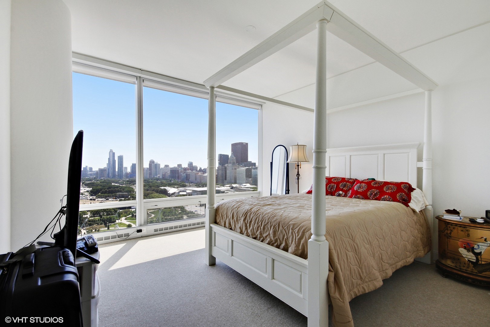 340 East Randolph Street, Unit 1803 Chicago, IL 60601 - Photo 8 of 19 a bedroom with a bed lamp and a large window