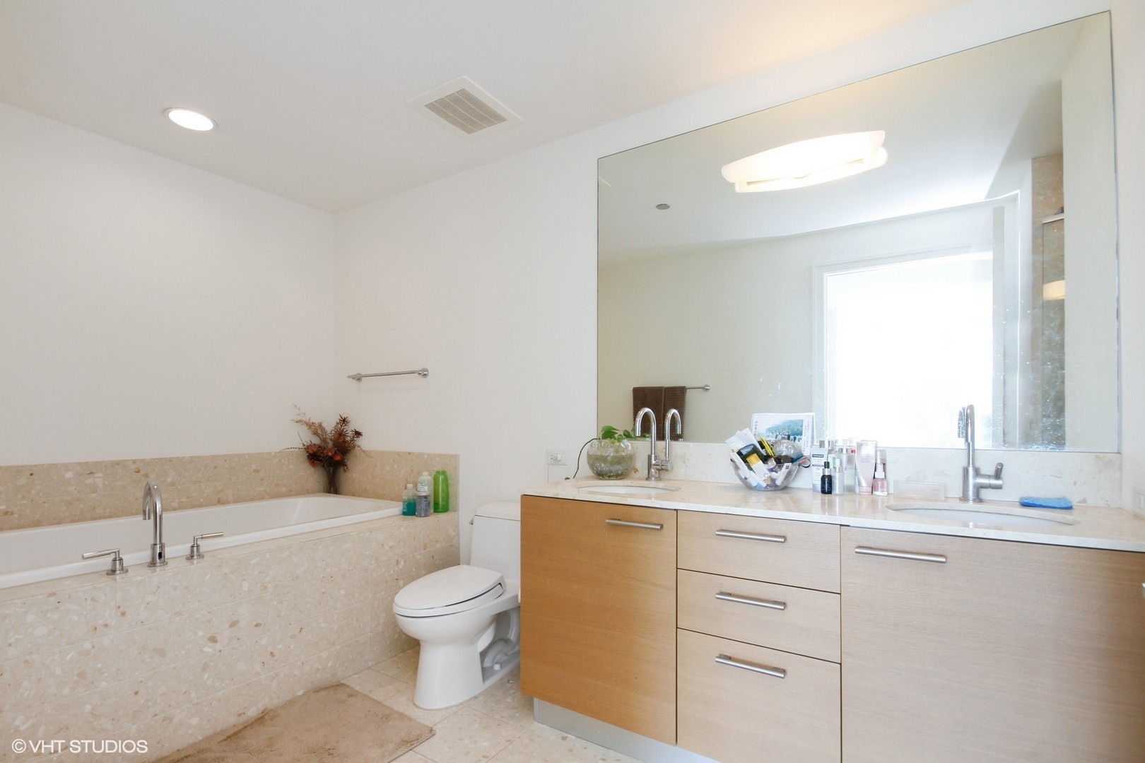340 East Randolph Street, Unit 1803 Chicago, IL 60601 - Photo 9 of 19 a bathroom with a toilet a sink a tub and mirror