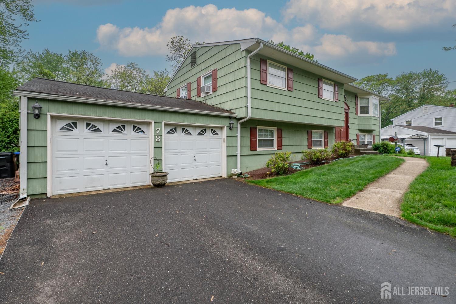73 Wellington Road East Brunswick, NJ 08816 - Photo 3 of 39 a front view of a house with a garage