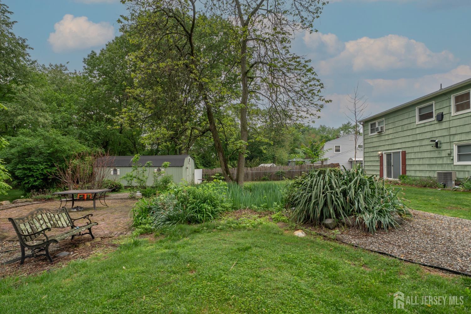 73 Wellington Road East Brunswick, NJ 08816 - Photo 37 of 39 a view of a backyard with plants and a large tree
