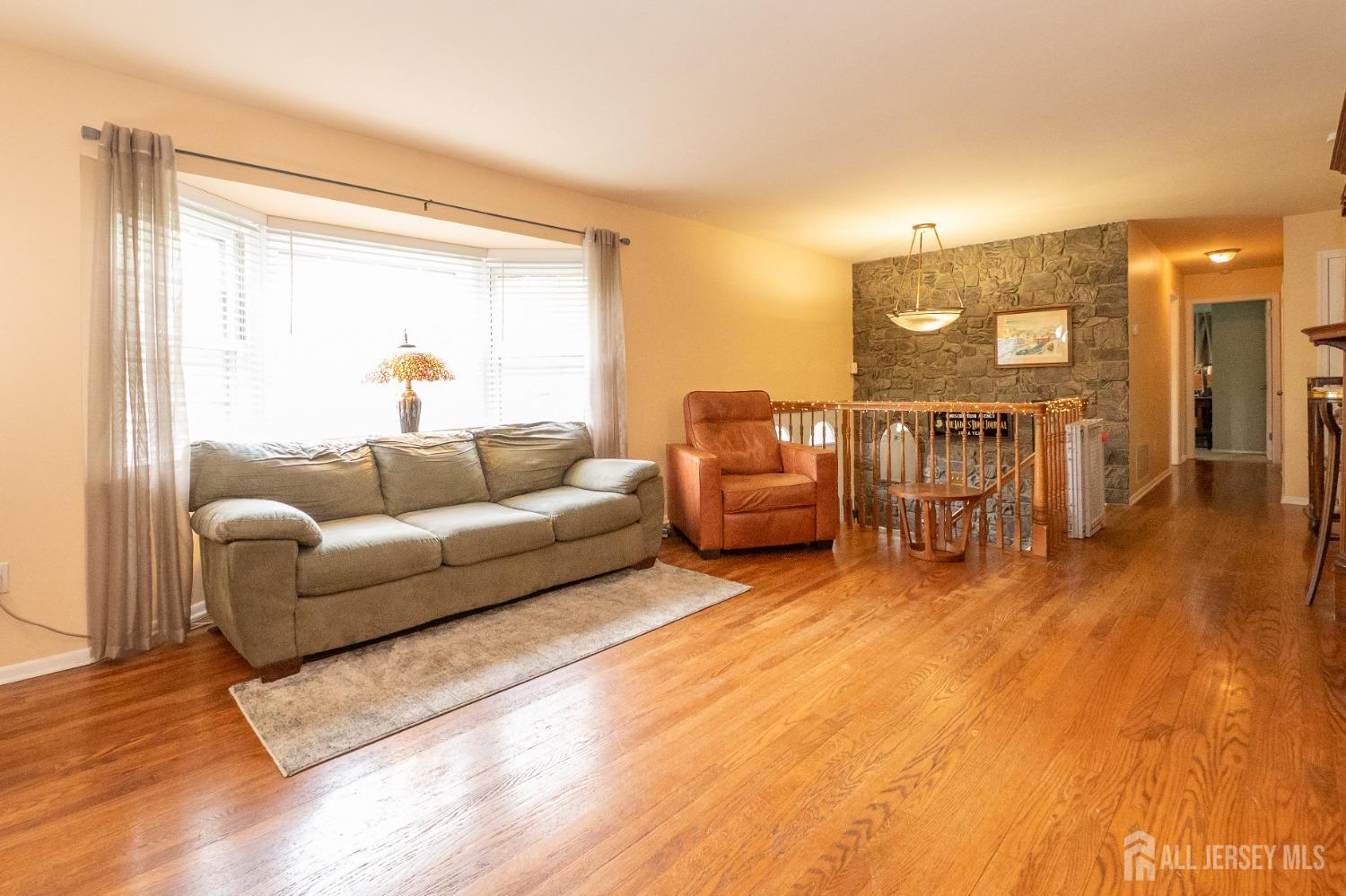 73 Wellington Road East Brunswick, NJ 08816 - Photo 5 of 39 a living room with furniture and a wooden floor
