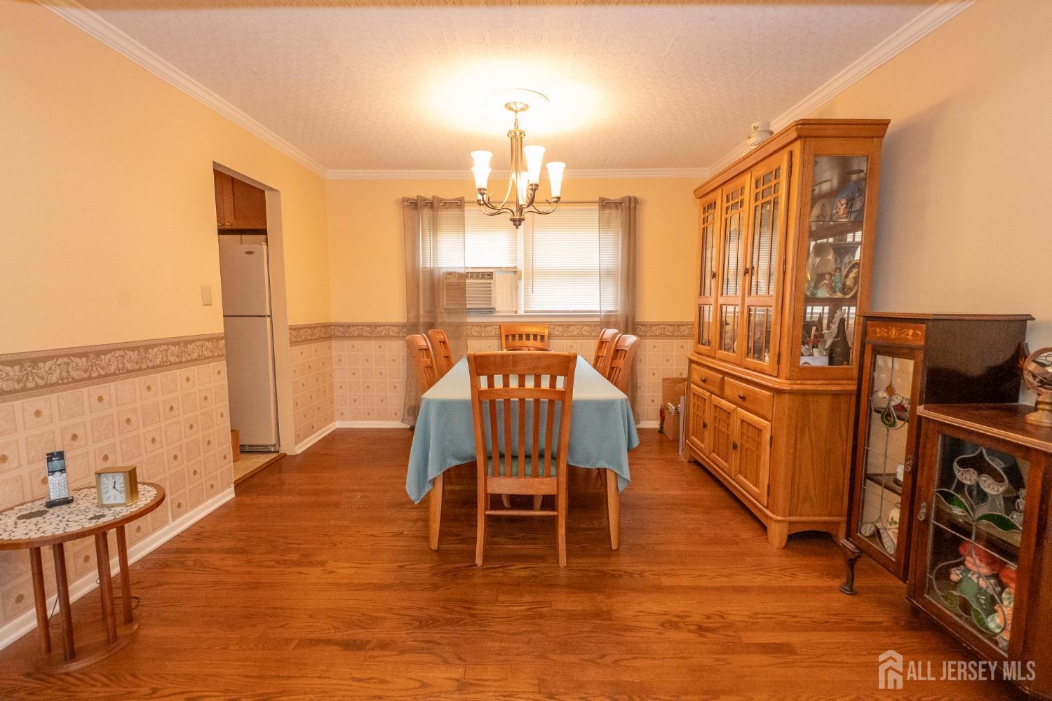 73 Wellington Road East Brunswick, NJ 08816 - Photo 7 of 39 a view of a dining room with furniture a chandelier and wooden floor