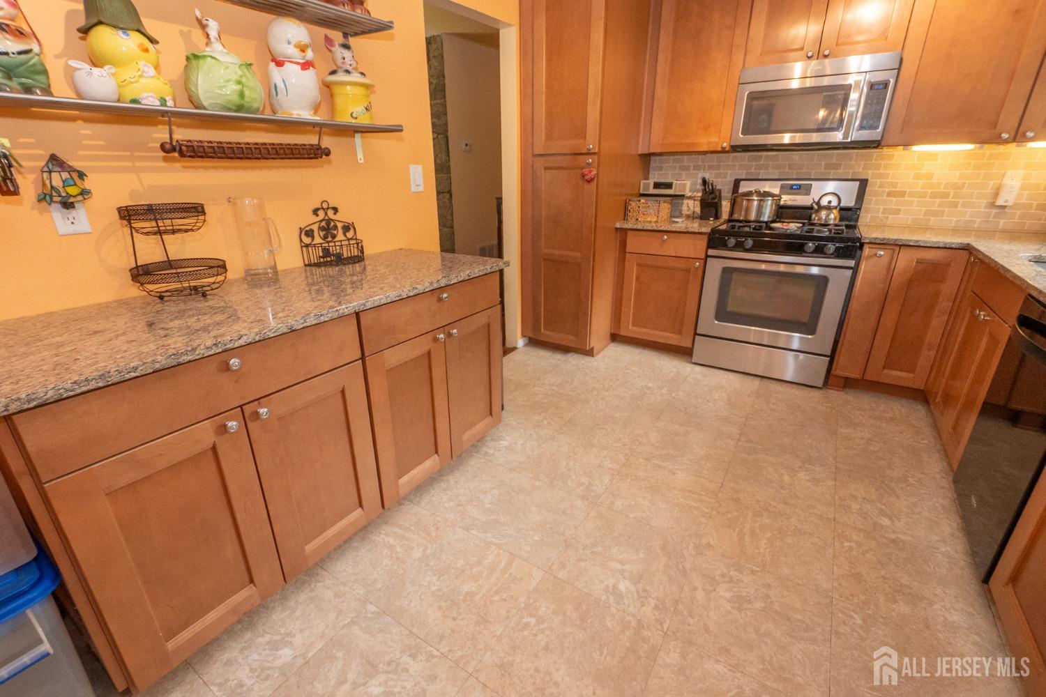 73 Wellington Road East Brunswick, NJ 08816 - Photo 9 of 39 a kitchen with cabinets and stainless steel appliances