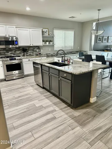 a kitchen with stainless steel appliances granite countertop a sink stove and cabinets