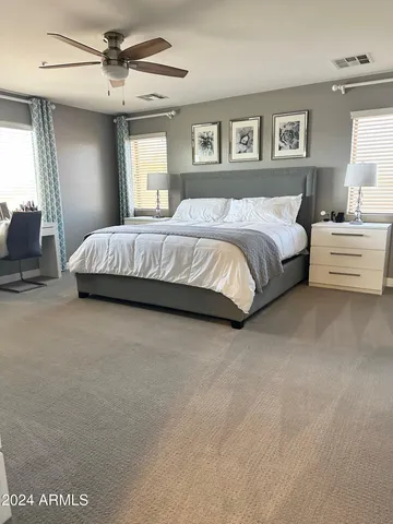 a spacious bedroom with a large bed and a chandelier