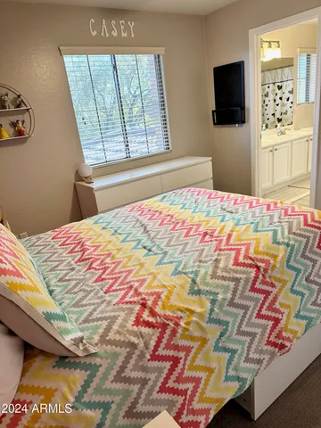 a bedroom with a bed and a flat screen tv