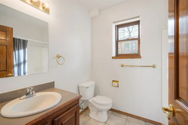 a bathroom with a granite countertop toilet sink and mirror