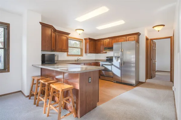 a kitchen with stainless steel appliances granite countertop a refrigerator and a stove top oven