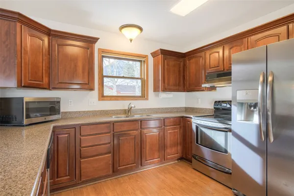 a kitchen with stainless steel appliances granite countertop a sink stove and refrigerator
