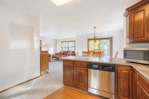 a kitchen with granite countertop a stove a sink dishwasher and a refrigerator