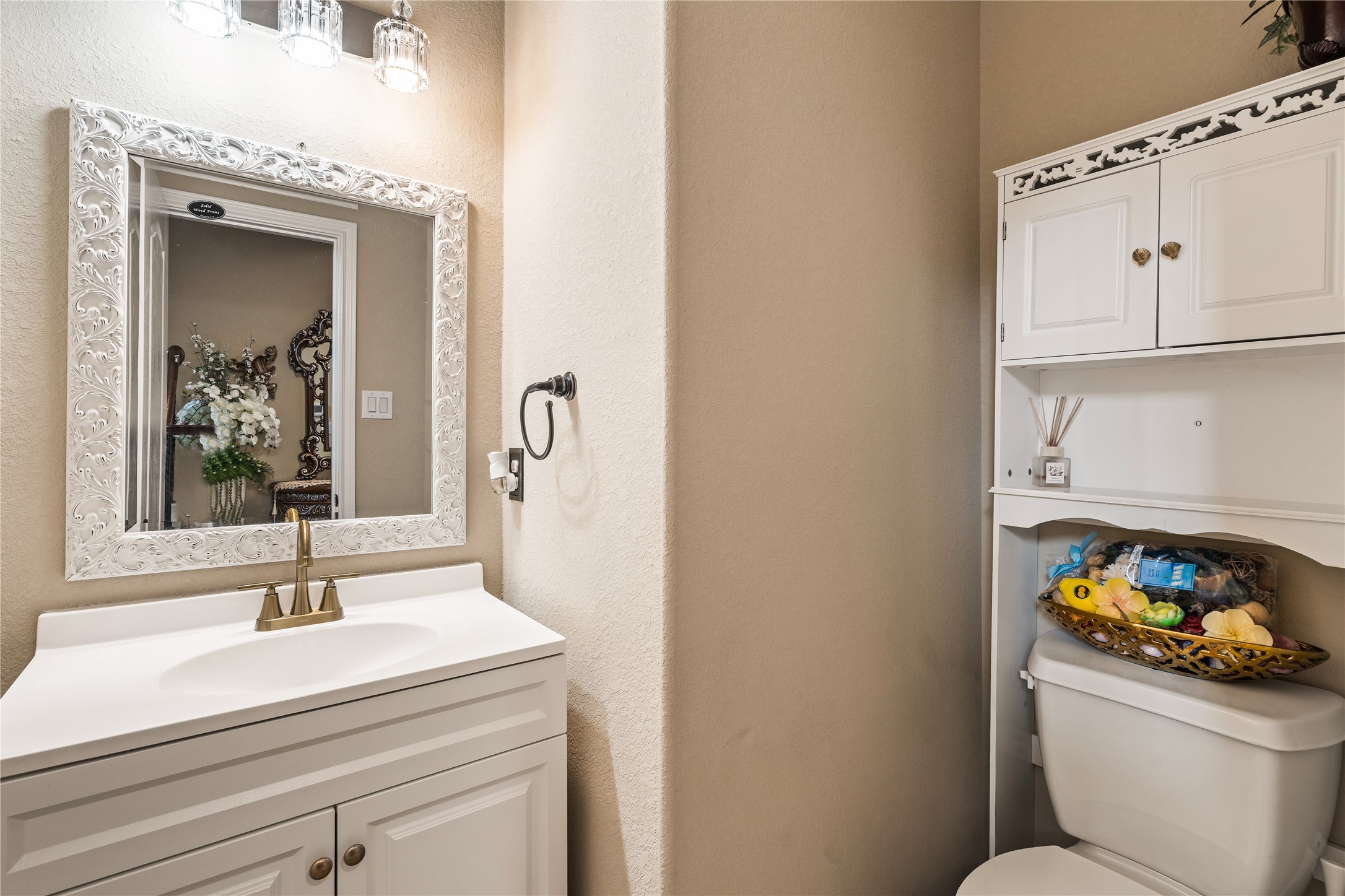 5802 Layton Meadows Lane Spring, TX 77379 - Photo 6 of 42 Downstairs powder bath. Ornate white carved mirror, gold hardware, crystal sconce.