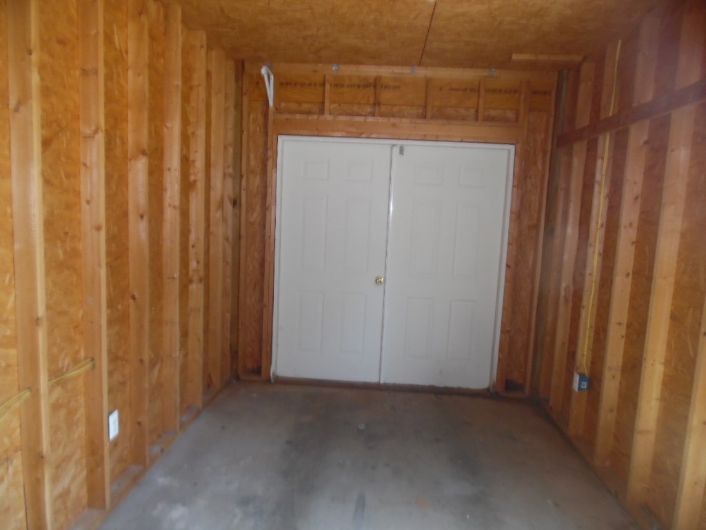 19 Haynes Street Due West, SC 29639 - Photo 3 of 8 A well-maintained utility room features sturdy wooden paneling and a durable concrete floor.