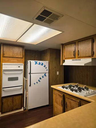 a kitchen with a stove a refrigerator and a stove top oven