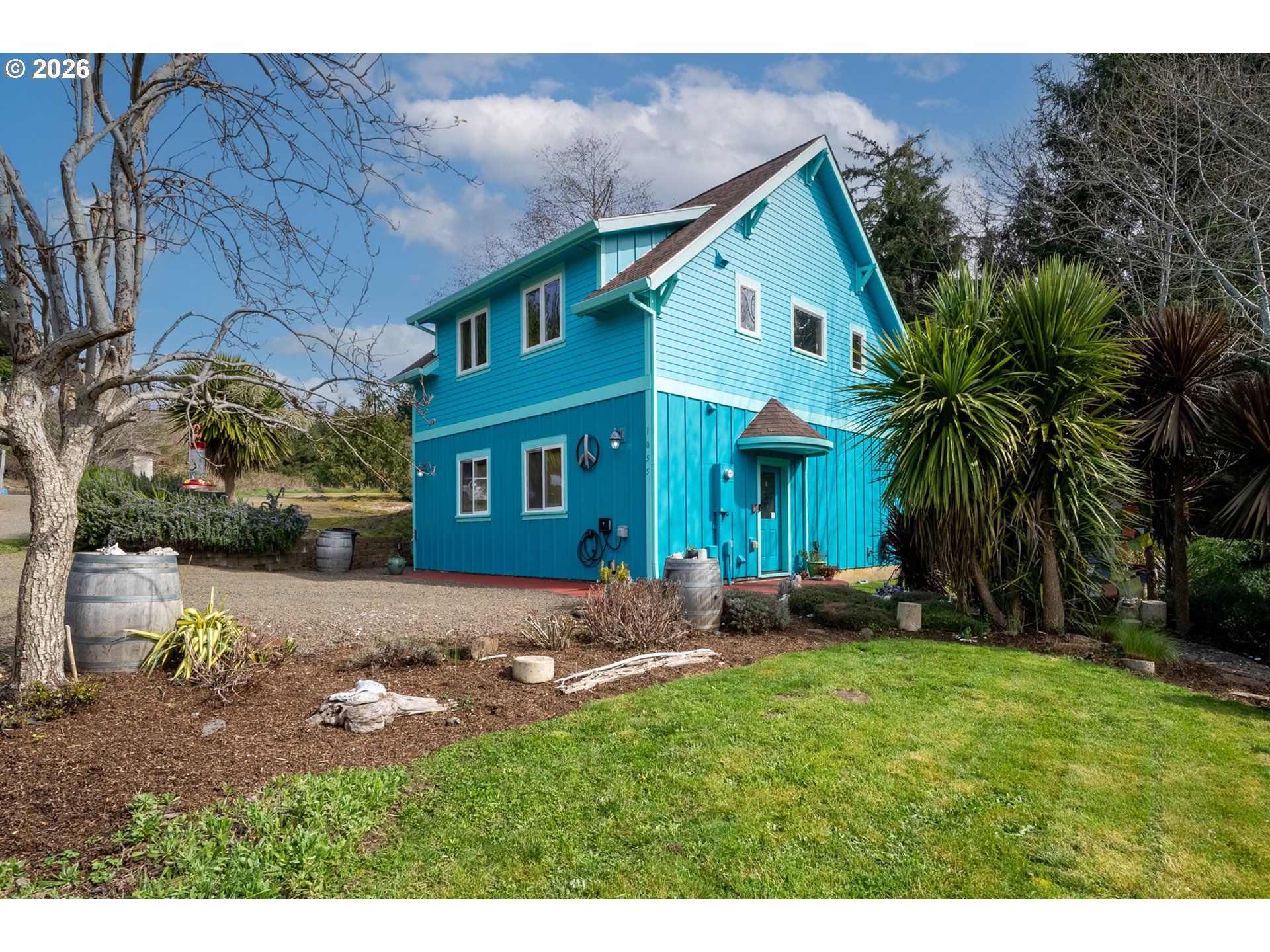 a front view of a house with a garden and yard