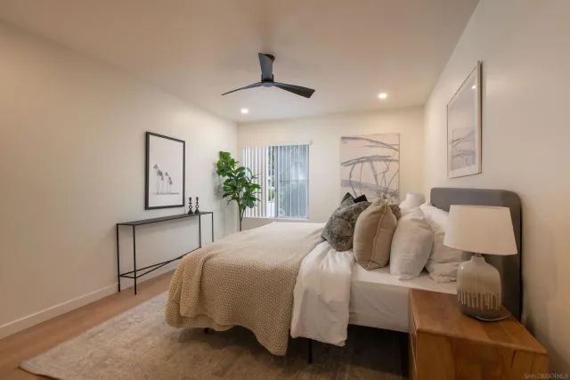 a bedroom with a bed a chandelier and a potted plant