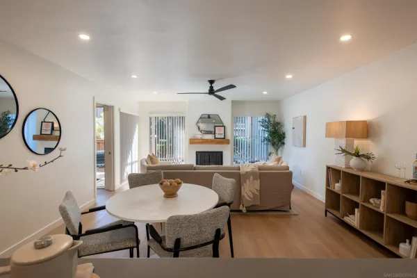 a living room with furniture a dining table and paintings on the wall