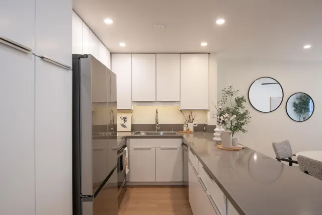 a kitchen with a sink cabinets a refrigerator and a sink
