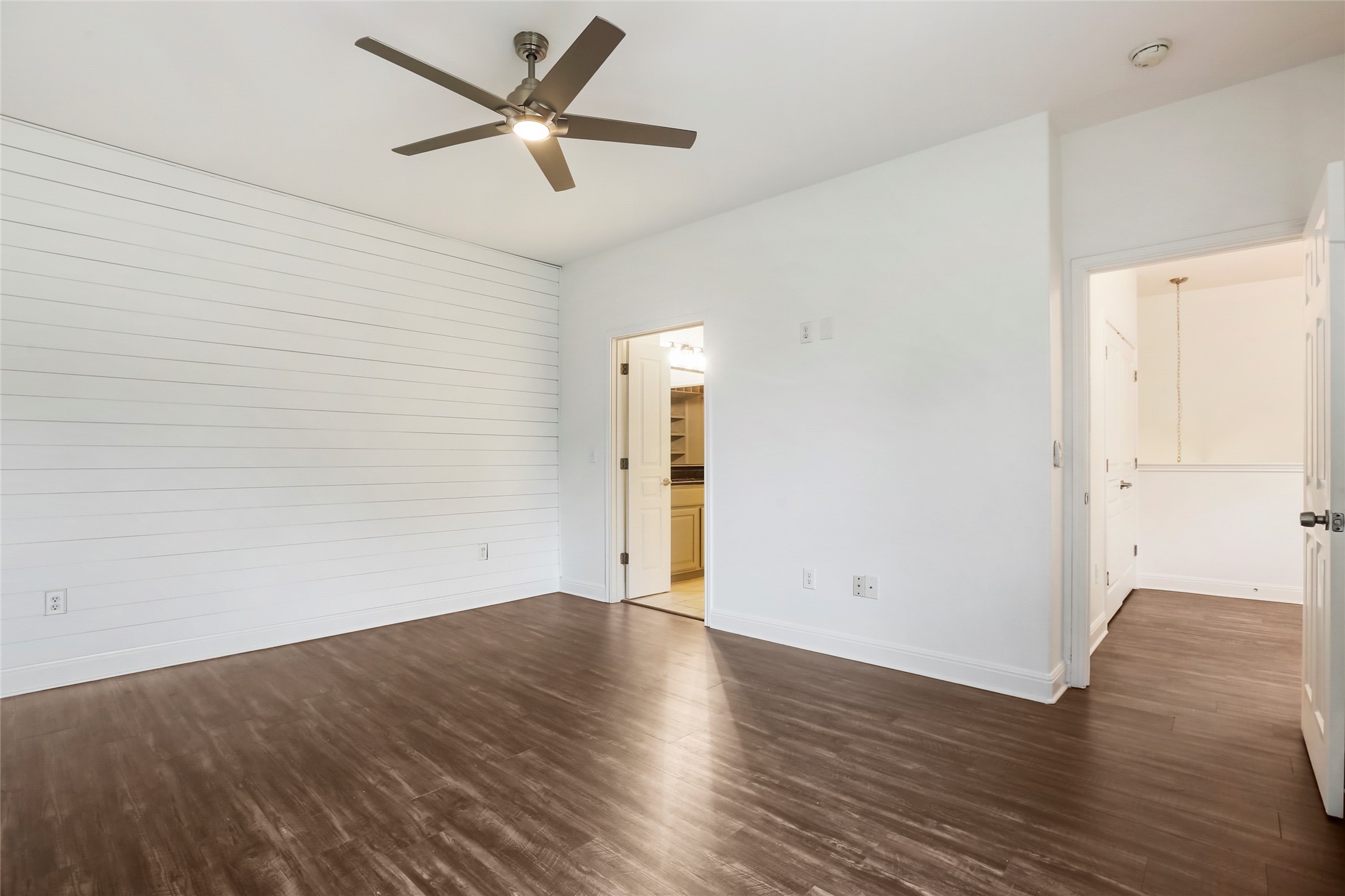3406 Menchaca Road, Unit 19 Austin, TX 78704 - Photo 21 of 25 Rich wood floors and a horizontal shiplap accent define this versatile bedroom space.