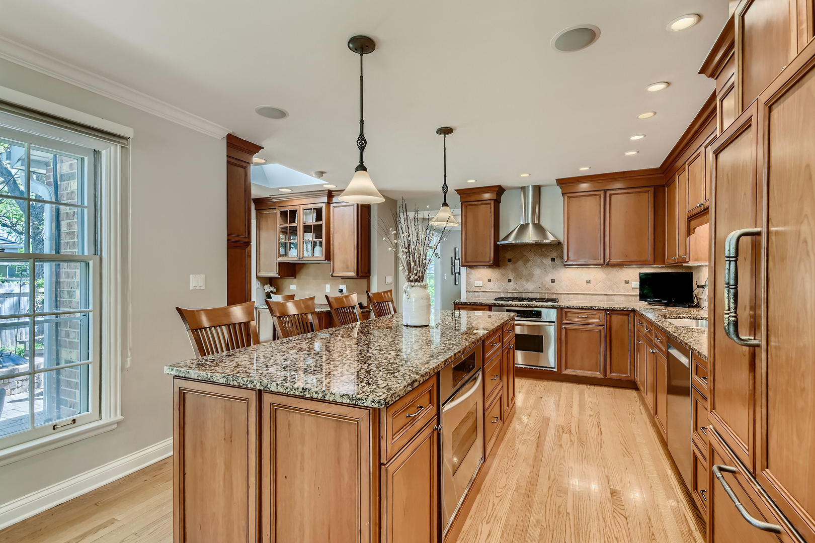 506 Warwick Road Deerfield, IL 60015 - Photo 8 of 34 a kitchen with stainless steel appliances granite countertop a sink a stove and a wooden floors