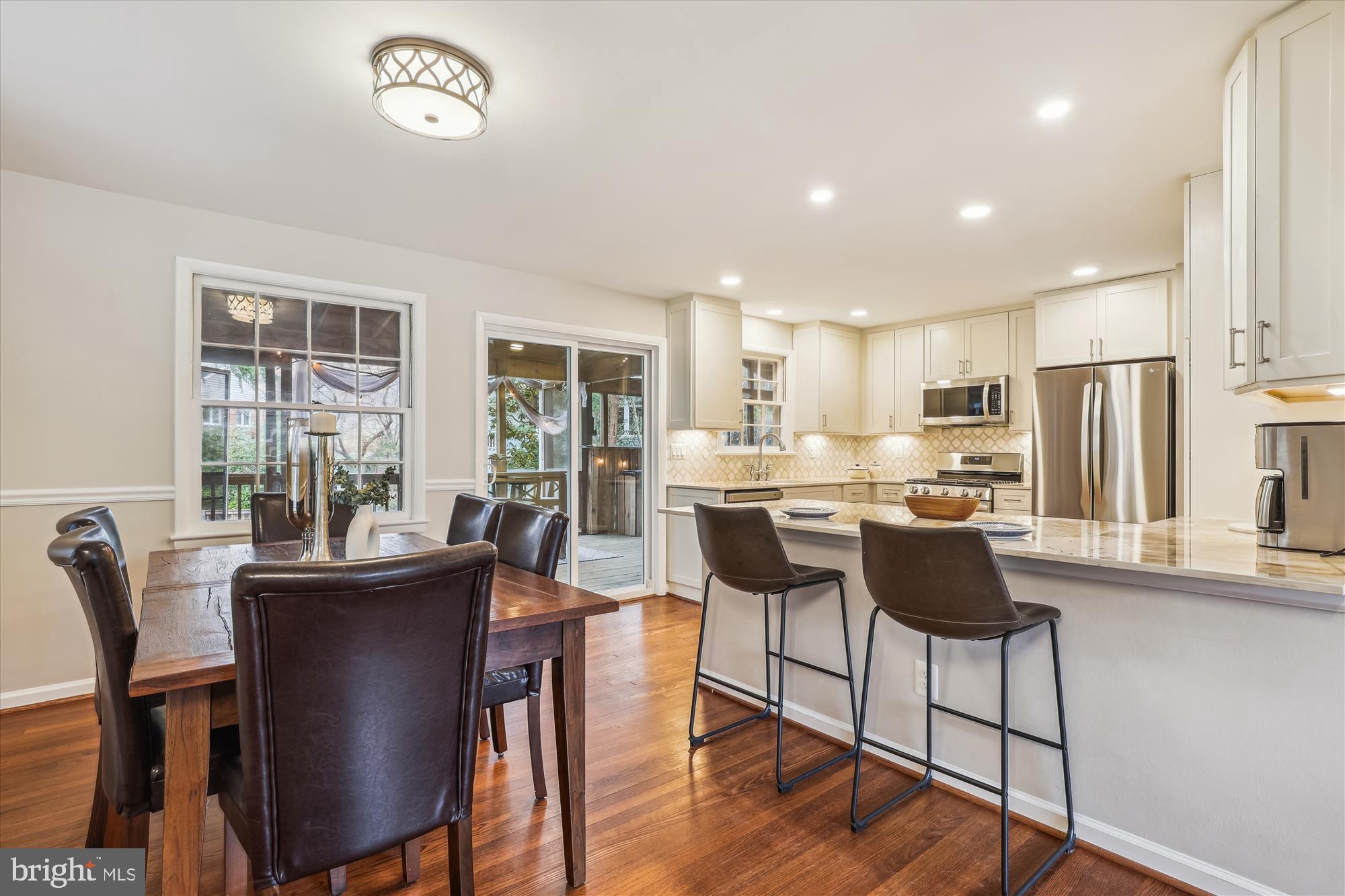 5413 Williamsburg Boulevard Arlington, VA 22207 - Photo 7 of 34 a kitchen with stainless steel appliances kitchen island granite countertop a dining table chairs and a refrigerator