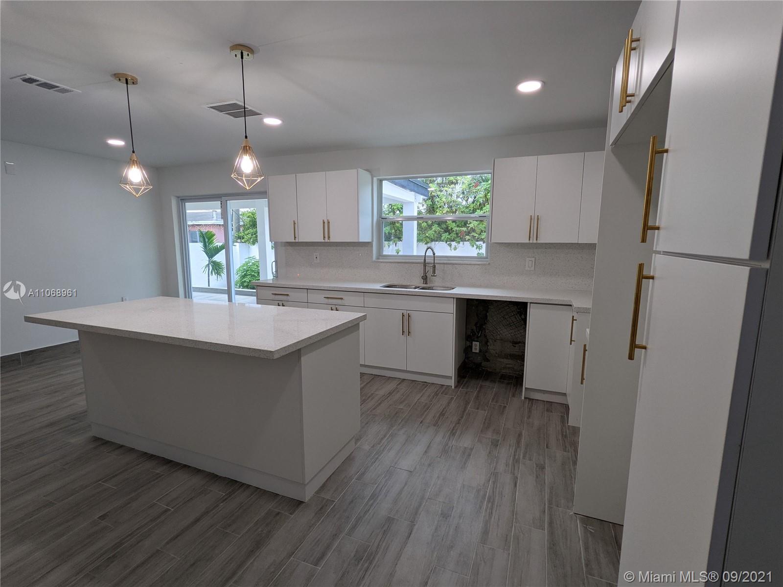 5675 Southwest 5th Street Miami, FL 33134 - Photo 11 of 20 a kitchen with kitchen island a sink stainless steel appliances and window