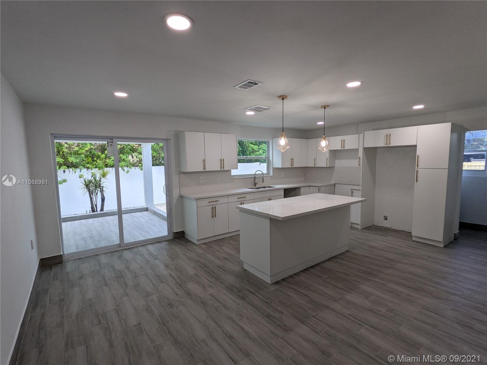 5675 Southwest 5th Street Miami, FL 33134 - Photo 8 of 20 a large kitchen with a large counter top a sink stainless steel appliances and cabinets