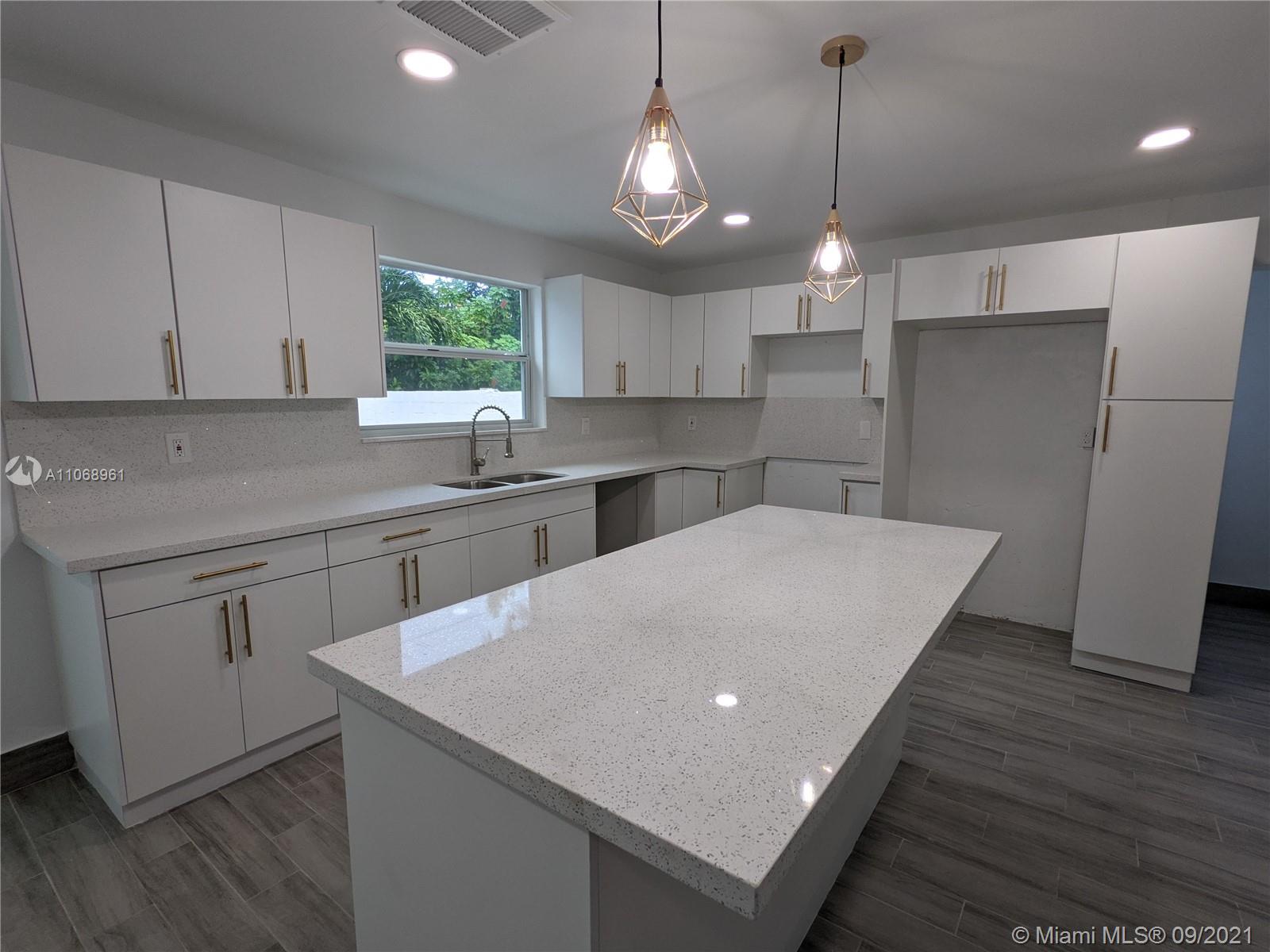5675 Southwest 5th Street Miami, FL 33134 - Photo 9 of 20 a kitchen with kitchen island a sink dishwasher a stove and white cabinets with wooden floor
