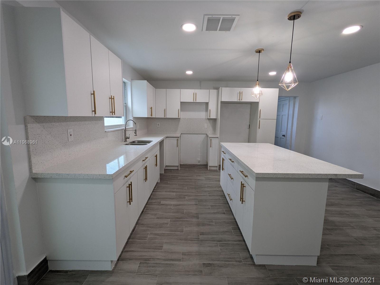 5675 Southwest 5th Street Miami, FL 33134 - Photo 10 of 20 a kitchen with lot of cabinets and wooden floor