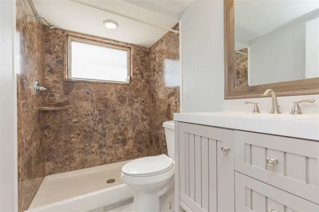 a bathroom with a sink toilet and shower
