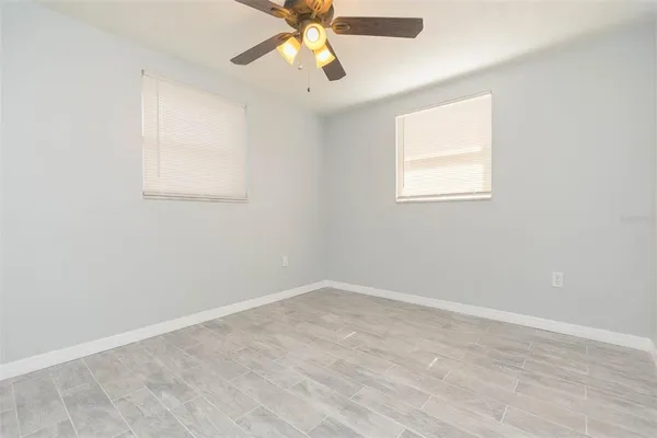 an empty room with a window and a fan