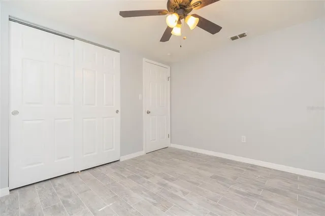 an empty room with a window and a fan
