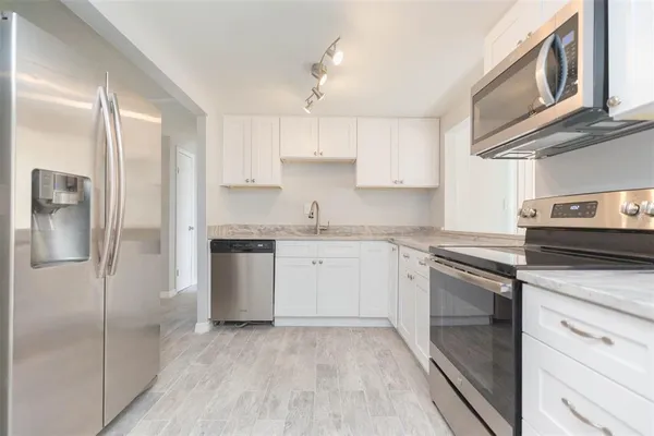 a kitchen with a refrigerator sink and cabinets
