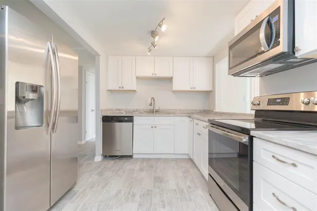 a kitchen with a refrigerator sink and cabinets