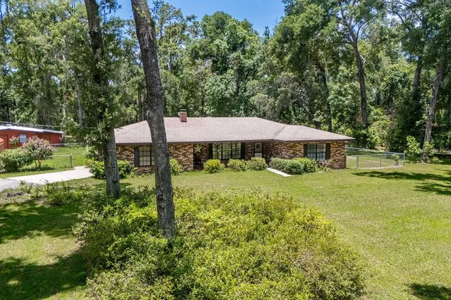 a view of a house with backyard and sitting area