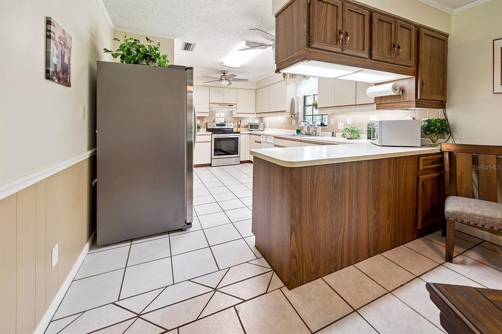 8991 Northwest 115th Street Chiefland, FL 32626 - Photo 31 of 49 a kitchen with stainless steel appliances a refrigerator sink and cabinets
