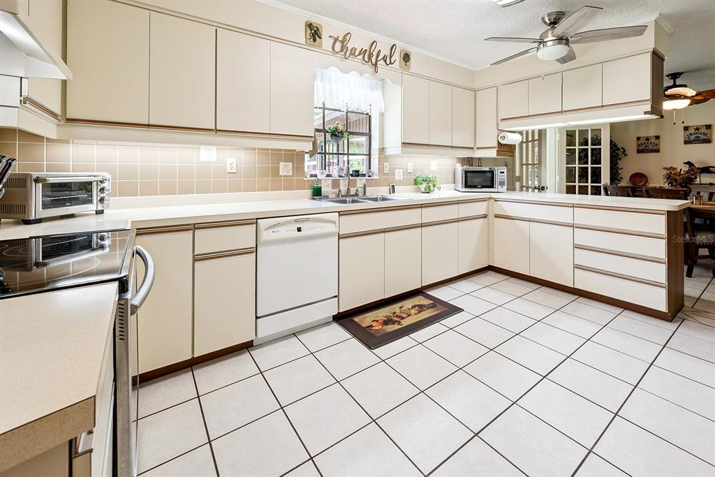 8991 Northwest 115th Street Chiefland, FL 32626 - Photo 33 of 49 a kitchen with cabinets and white appliances