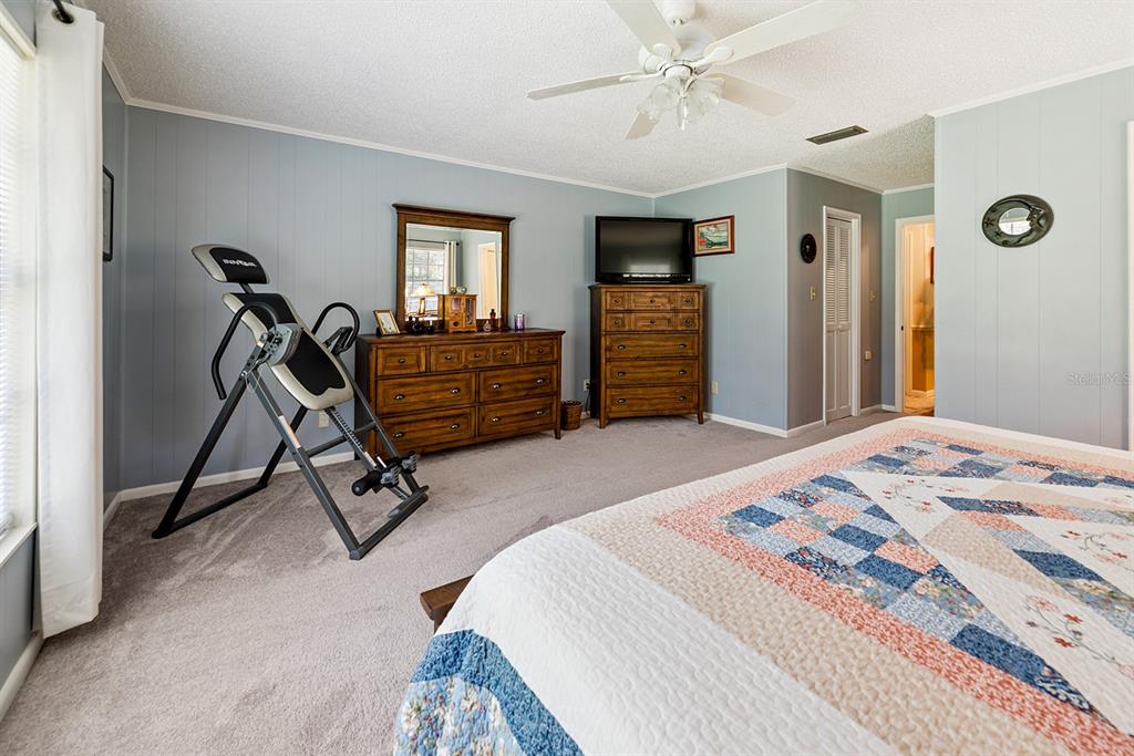 8991 Northwest 115th Street Chiefland, FL 32626 - Photo 48 of 49 a bedroom with a bed and a chandelier