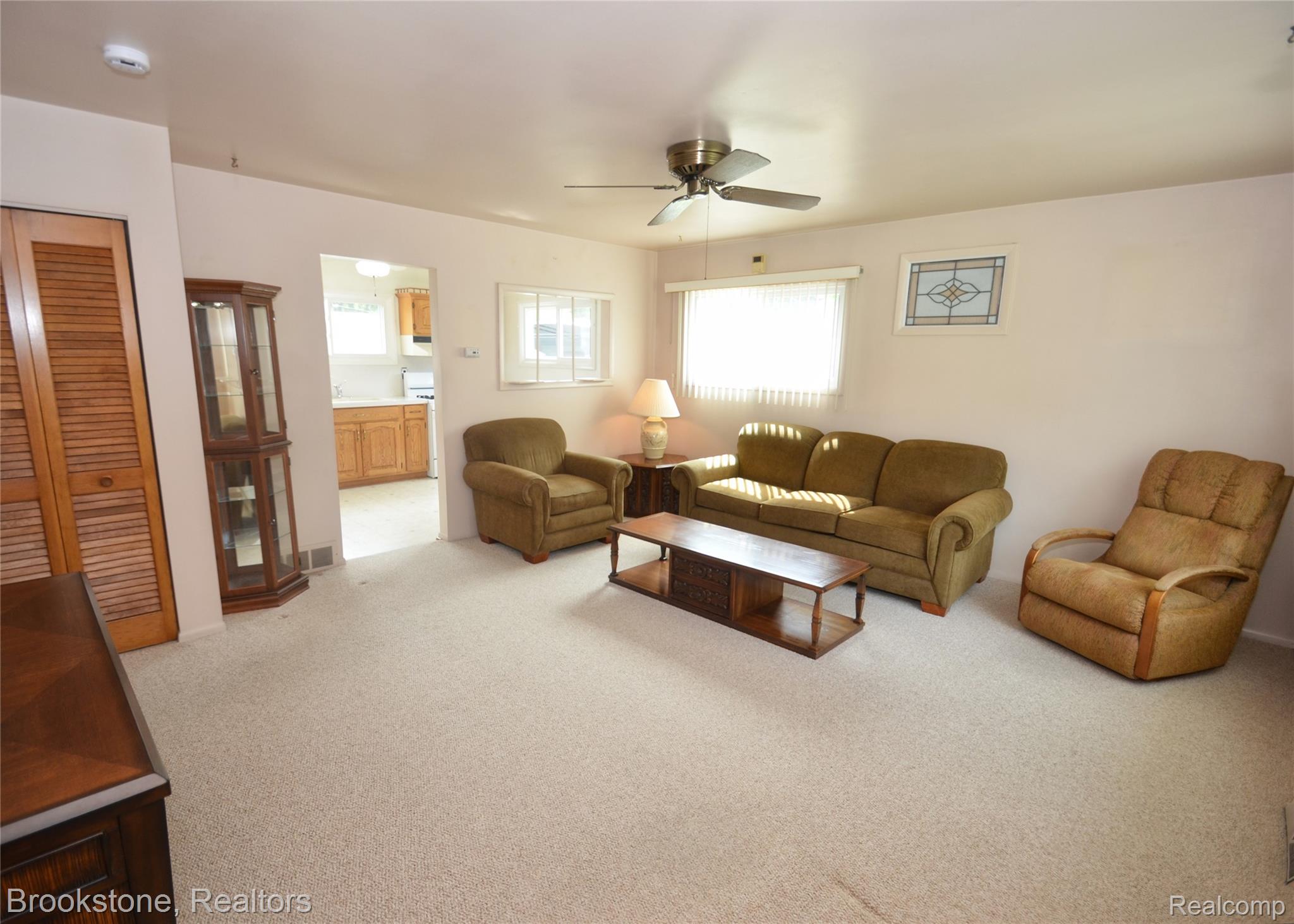 2822 Frembes Road Waterford, MI 48329 - Photo 4 of 25 Carpeted living space featuring a ceiling fan, a window with horizontal blinds, and a decorative stained glass-style window
