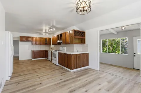 a large kitchen with stainless steel appliances granite countertop a large counter top and wooden floors