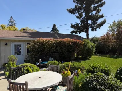 a view of a chairs and table in the patio with a yard