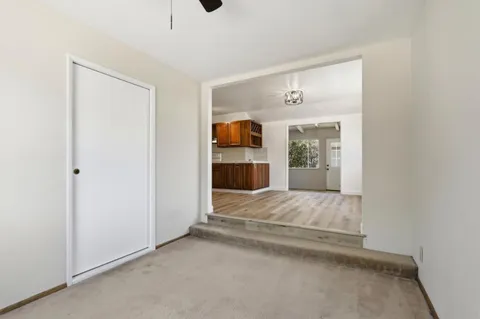 an empty room with windows and ceiling fan