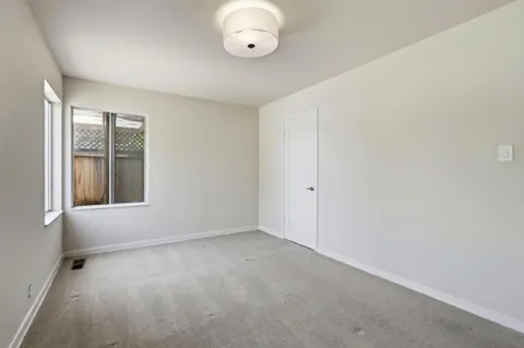 an empty room with windows and ceiling fan