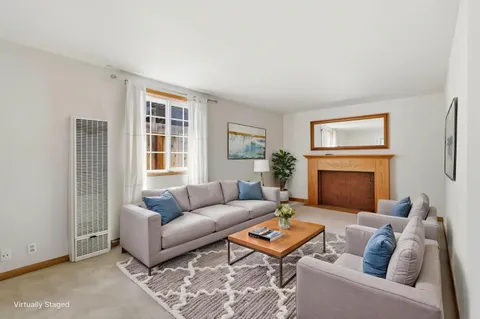 a living room with furniture a fireplace and a window