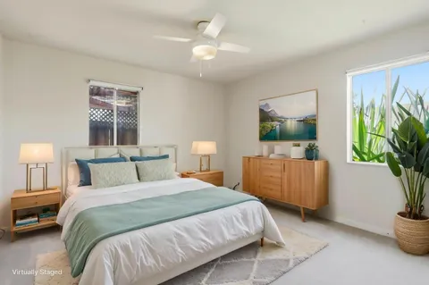a bedroom with a bed a couch and a potted plant