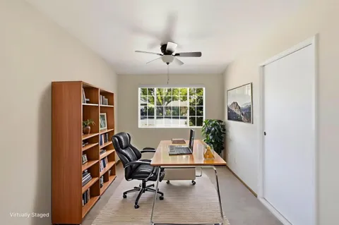 a view of a workspace with furniture and a window
