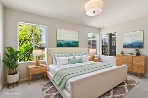 a bedroom with a large bed and a potted plant