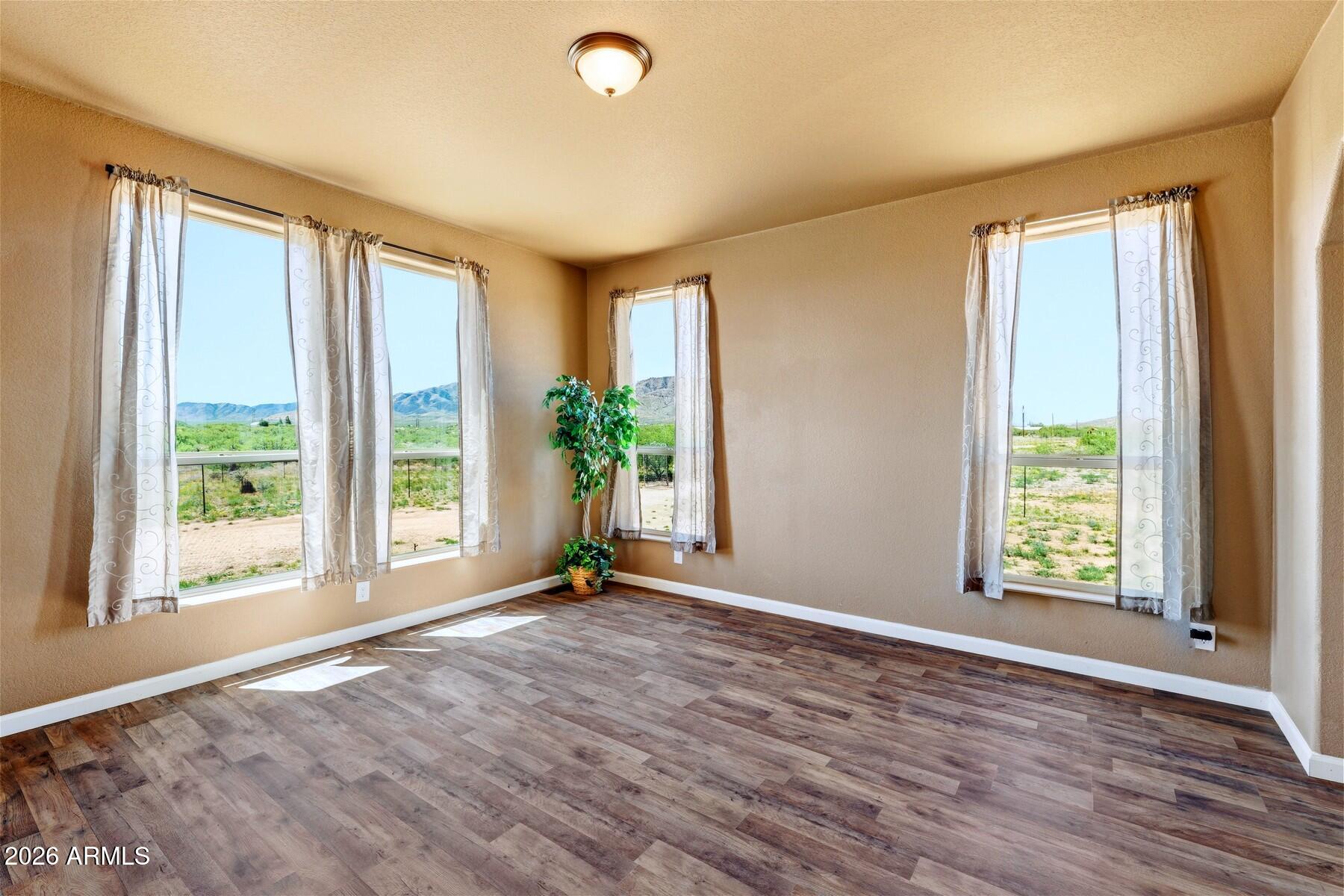 3216 North Mesquite Road Cochise, AZ 85606 - Photo 13 of 39 a view of an empty room with a window and wooden floor