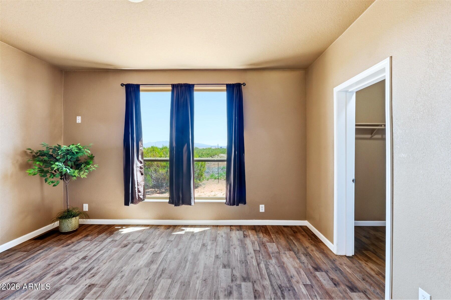 3216 North Mesquite Road Cochise, AZ 85606 - Photo 25 of 39 a view of an empty room with window and wooden floor