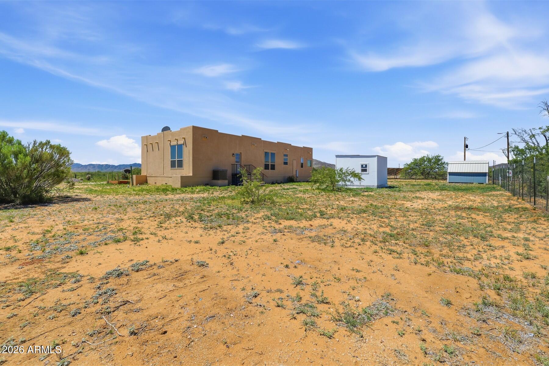3216 North Mesquite Road Cochise, AZ 85606 - Photo 29 of 39 a big yard with a building in the background