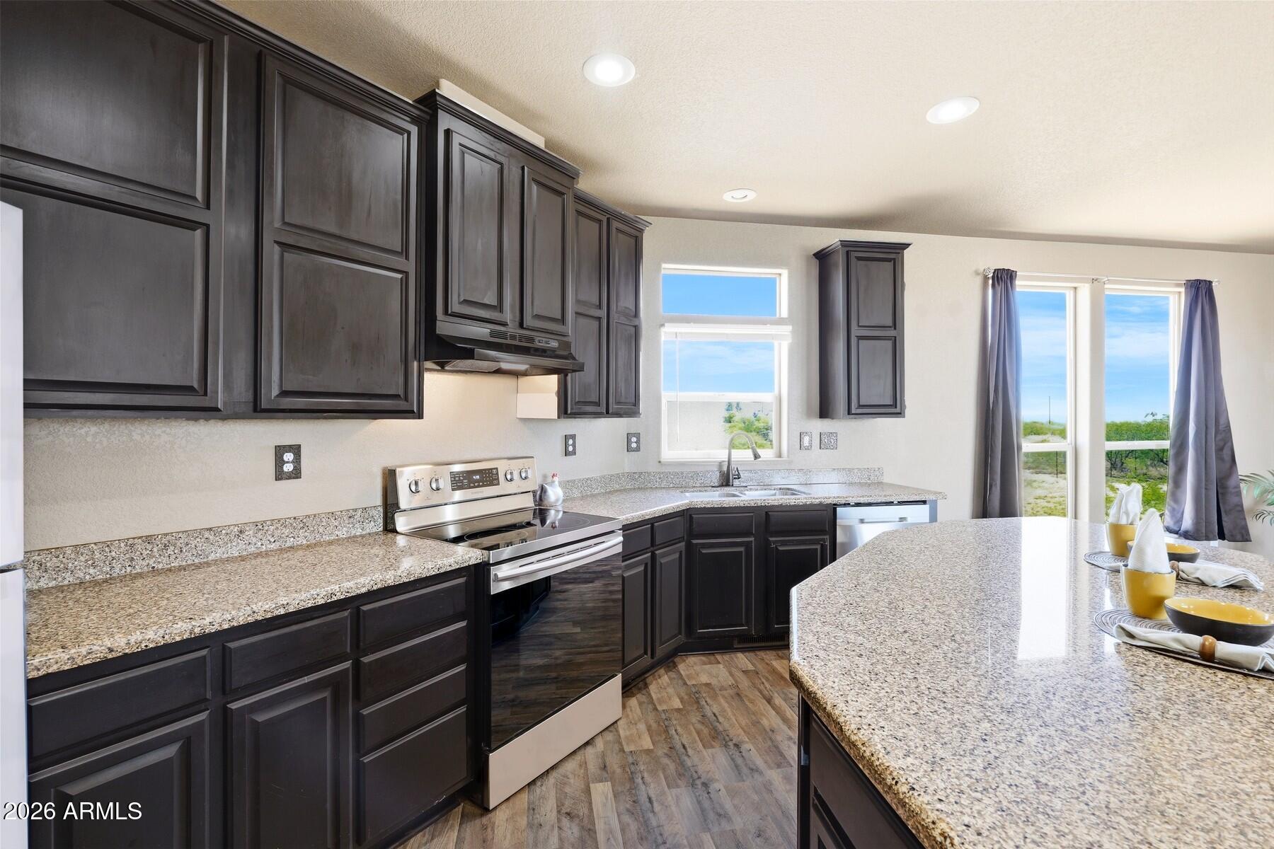 3216 North Mesquite Road Cochise, AZ 85606 - Photo 9 of 39 a kitchen with granite countertop stainless steel appliances sink stove microwave and cabinets